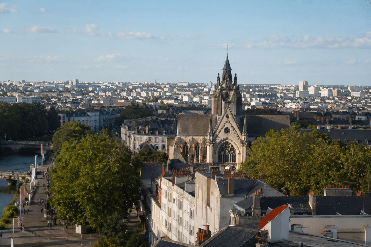 Église gothique à flèche dominant des toits et arbres