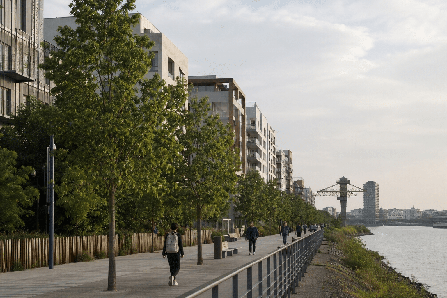 Promenade riveraine bordée d'arbres, immeubles et passants