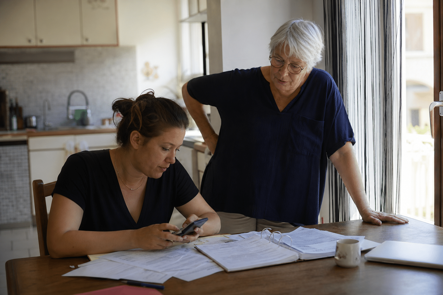 Jeune femme remplissant des papiers, femme plus âgée observant