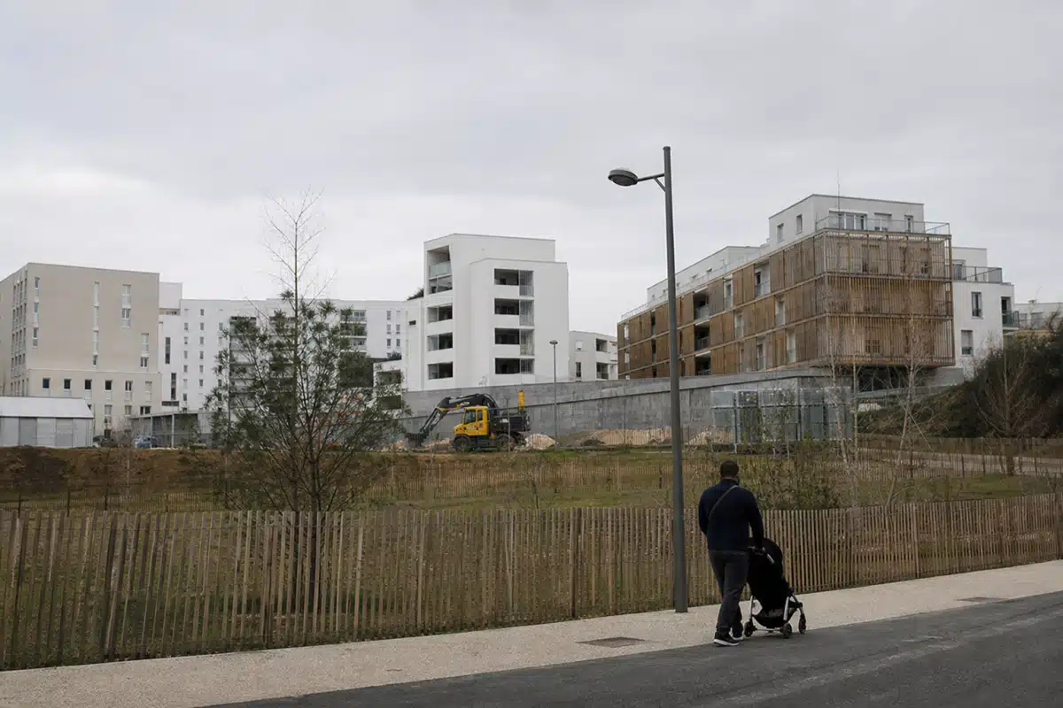 Personne poussant une poussette devant un chantier