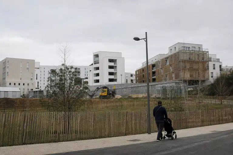 Personne poussant une poussette devant un chantier